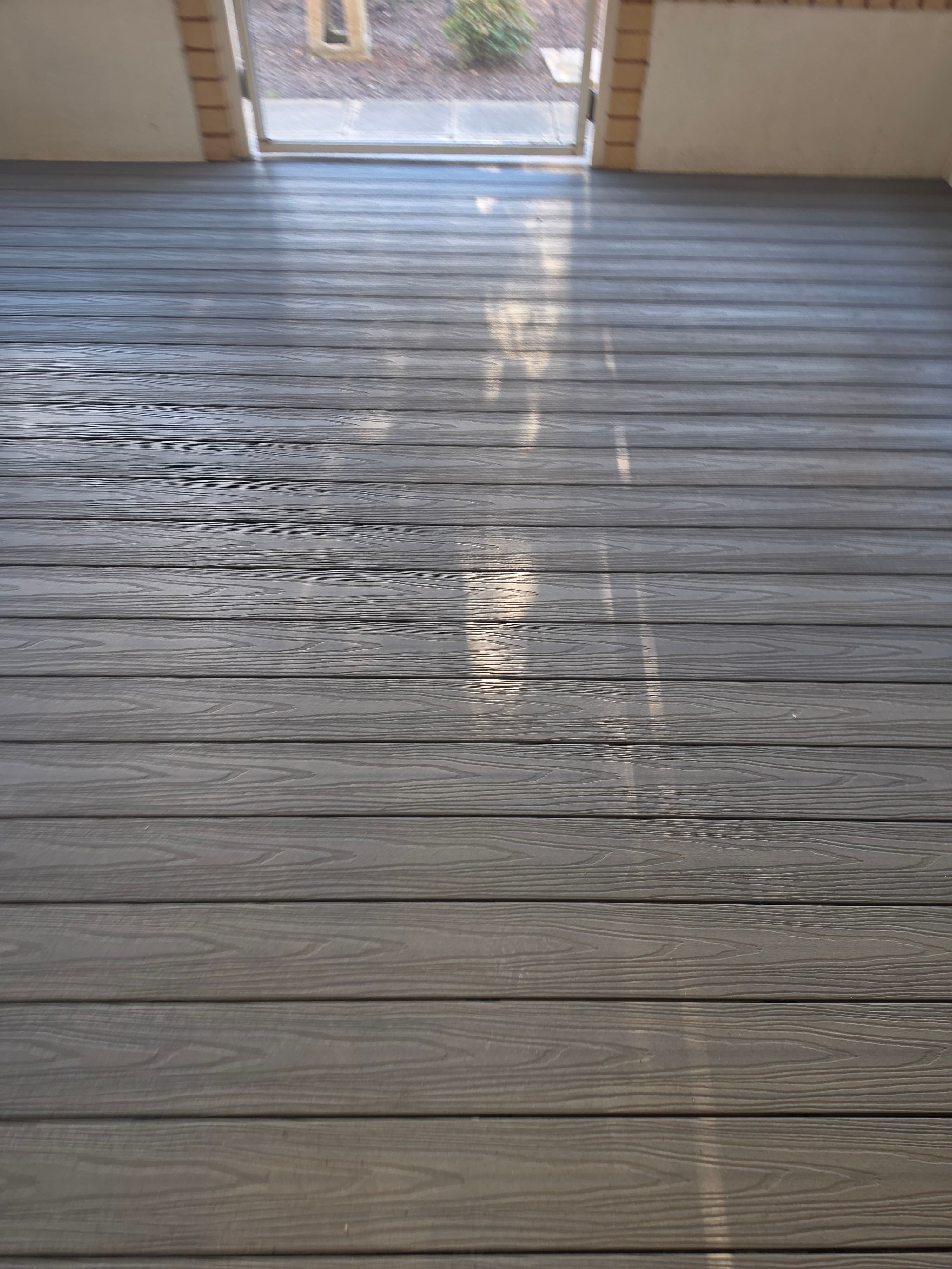 Close-up of MexyTech composite decking showing its deep, realistic woodgrain texture