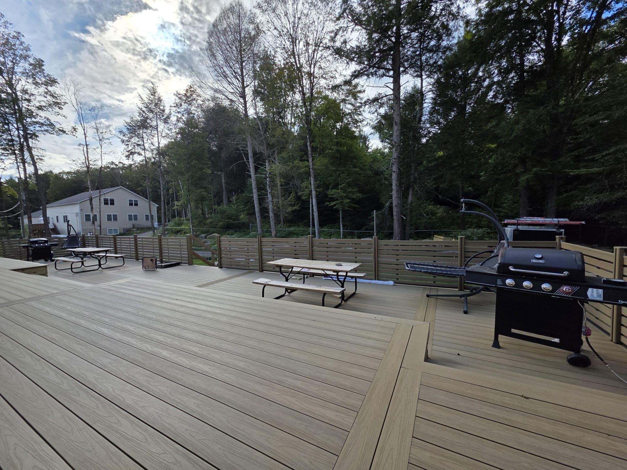 MexyTech Suprotect composite decking and matching privacy screen on a backyard deck