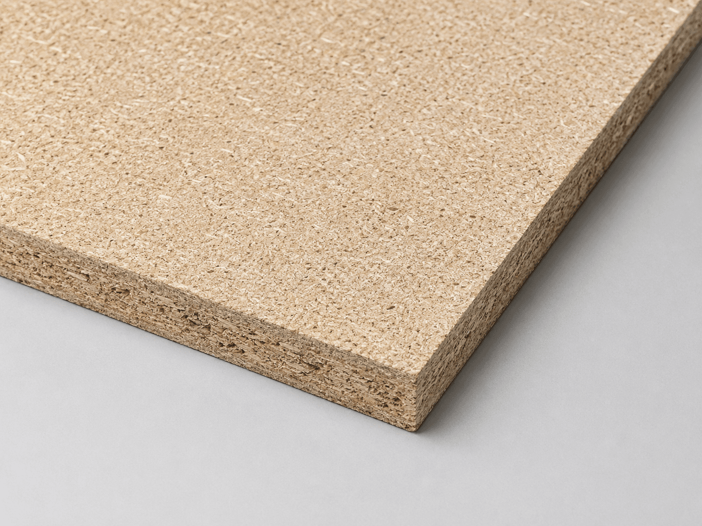 A particle board sheet showing its compressed wood-chip surface and edge