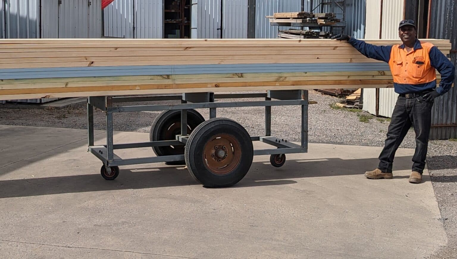 An Allmat team member loading timber onto a trolley